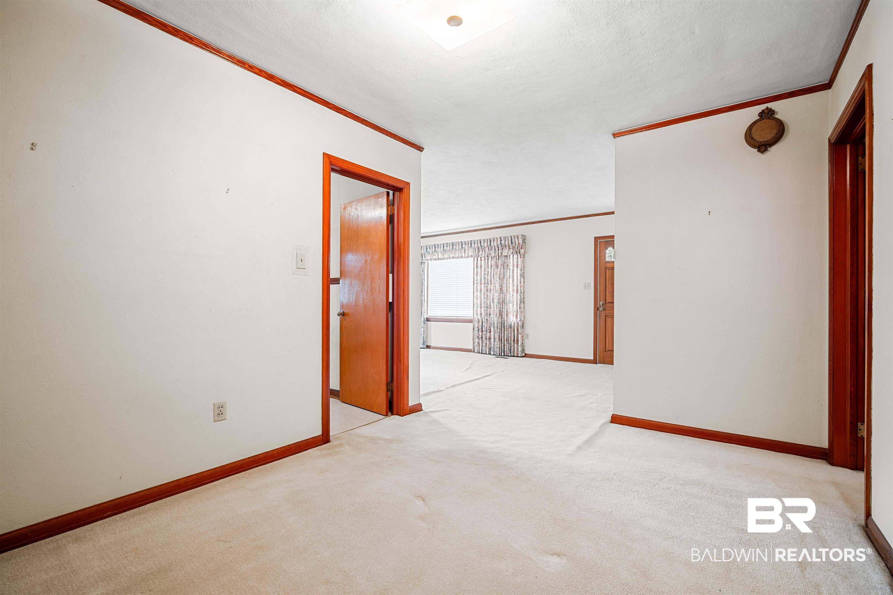 2300 Ellen Drive Mobile, AL 36605 - Photo 14 of 25 Spare room featuring crown molding, a textured ceiling, and light colored carpet
