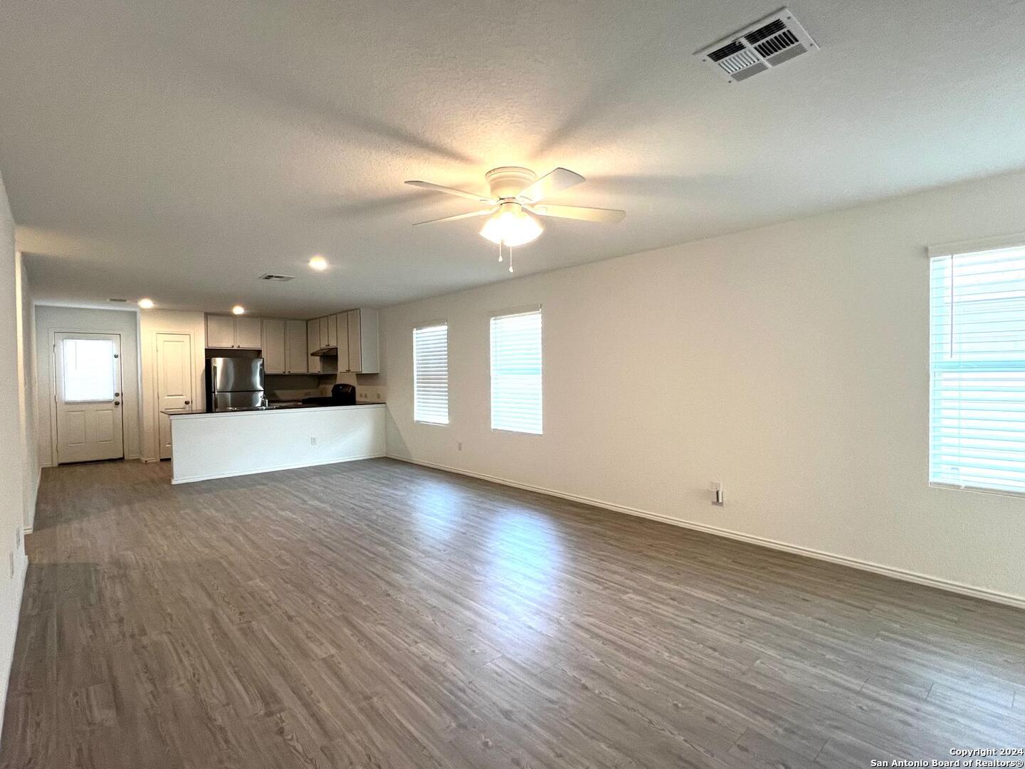 9928 Leeds Wheel San Antonio, TX 78254 - Photo 3 of 11 a view of a livingroom with a kitchen stove wooden cabinets and a window