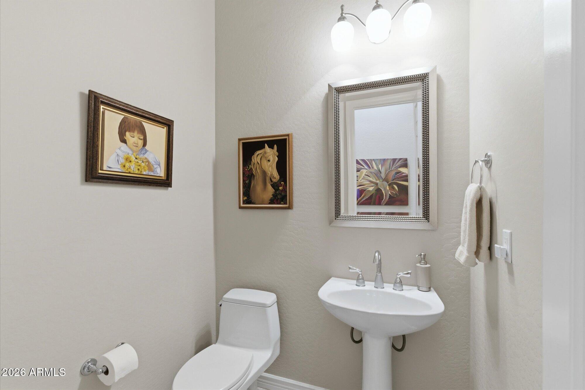 40322 North Hawk Ridge Trail Anthem, AZ 85086 - Photo 41 of 63 a bathroom with a toilet sink and mirror