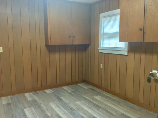 an empty room with wooden floor and cabinet