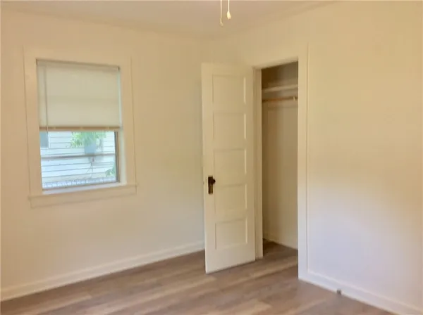 an empty room with wooden floor and a window