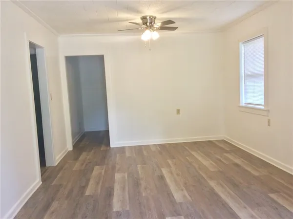 a view of room with hardwood floor and a ceiling fan