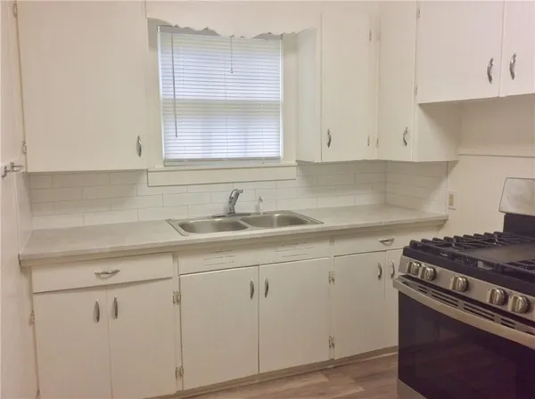 a kitchen with white cabinets and a sink