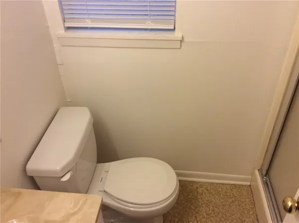 a white toilet sitting next to a shower