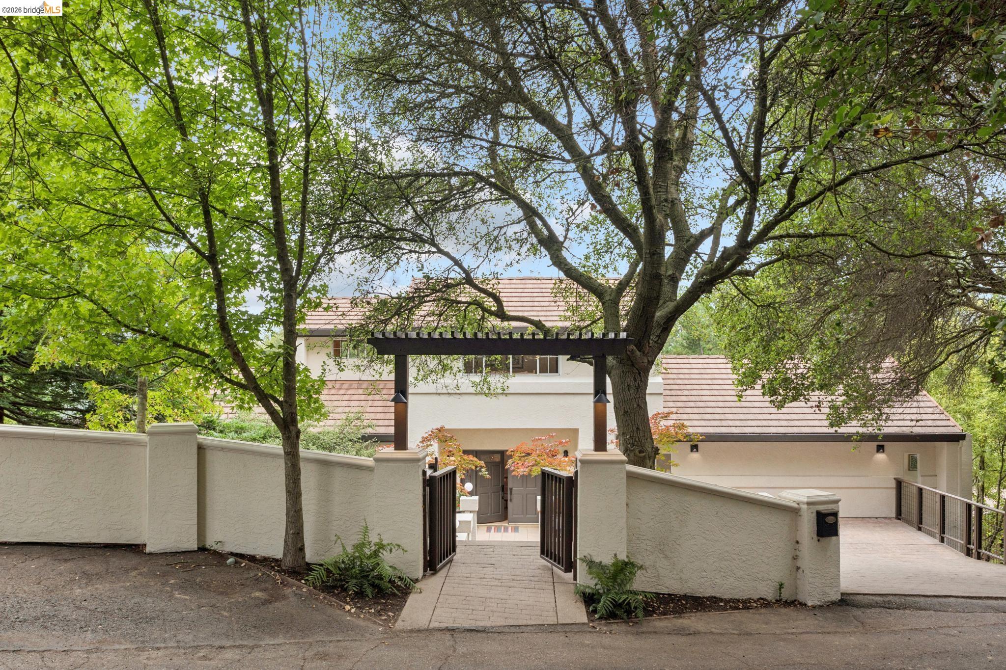 1325 Drury Road Berkeley, CA 94705 - Photo 5 of 71 Gated entry leading to a stucco residence with a terracotta tile roof