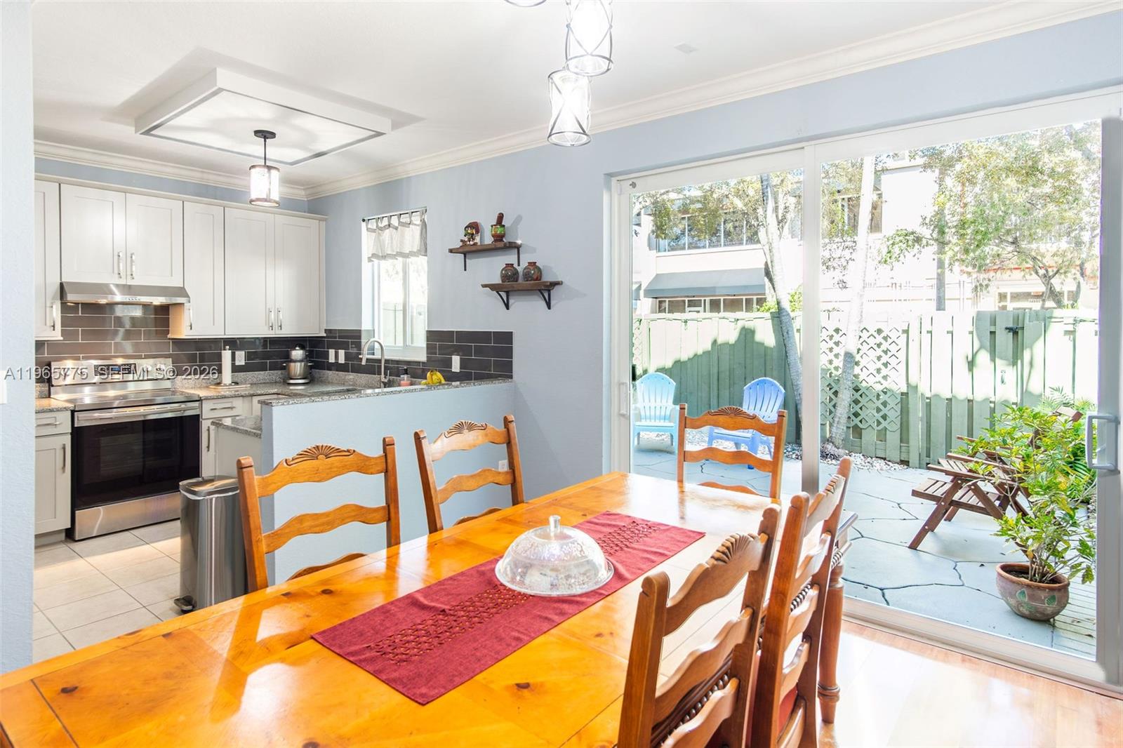 12523 Southwest 121st Way Miami, FL 33186 - Photo 16 of 56 a kitchen with stainless steel appliances granite countertop a stove a sink dishwasher and white cabinets with wooden floor
