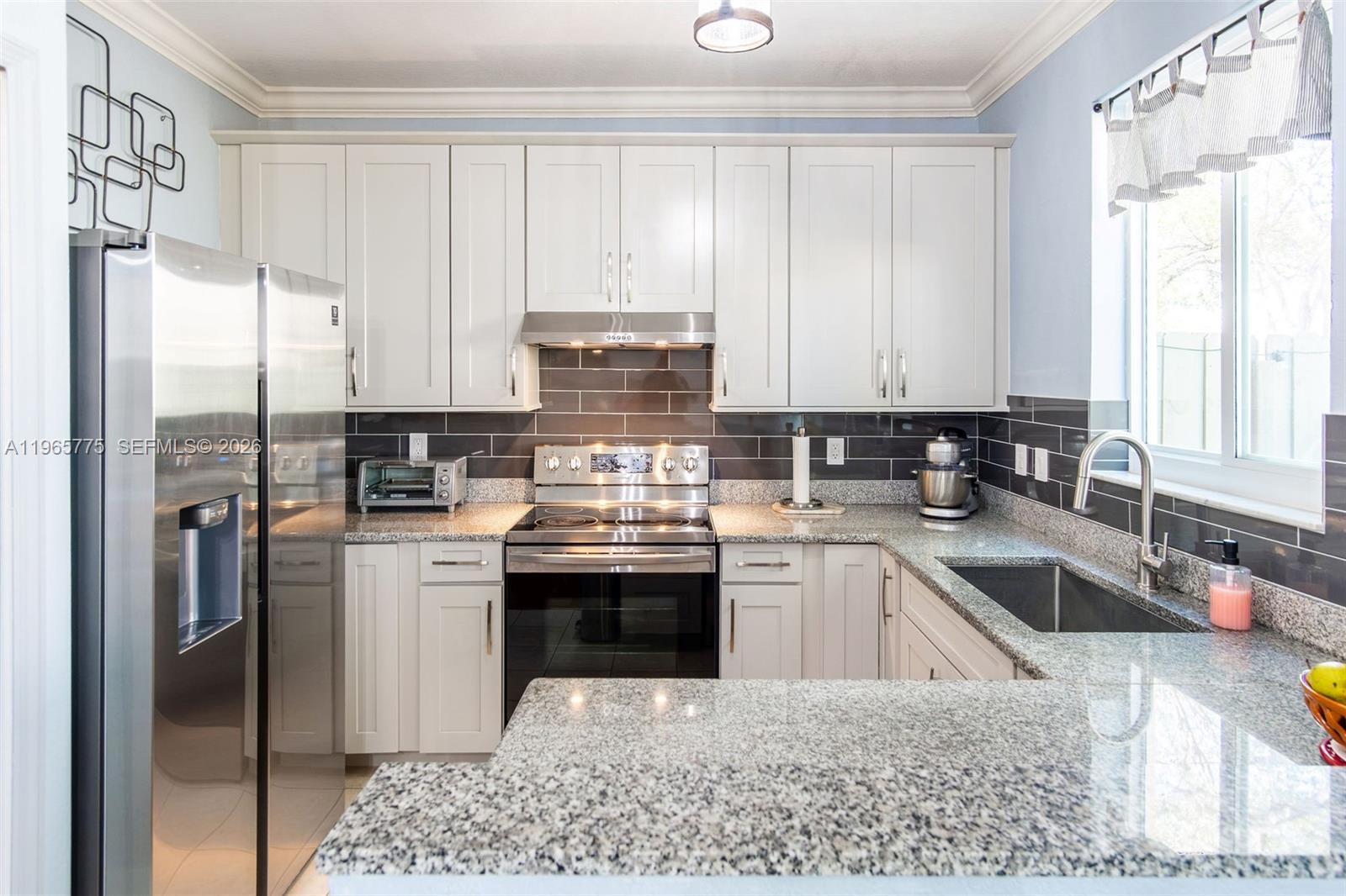 12523 Southwest 121st Way Miami, FL 33186 - Photo 17 of 56 a kitchen with stainless steel appliances granite countertop a sink a stove and a refrigerator