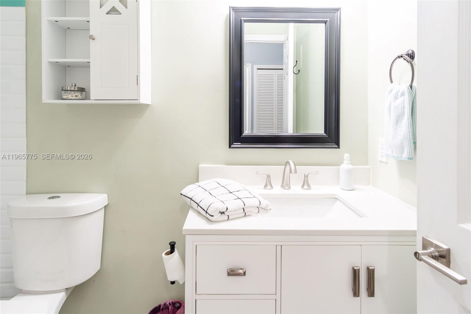 12523 Southwest 121st Way Miami, FL 33186 - Photo 29 of 56 a bathroom with a sink a toilet and mirror