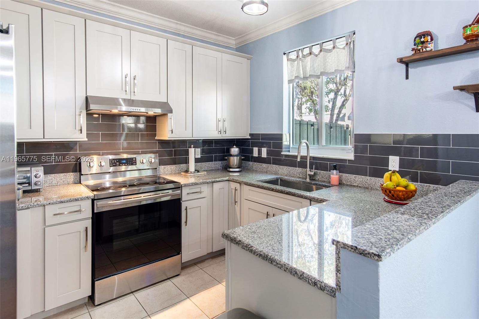 12523 Southwest 121st Way Miami, FL 33186 - Photo 4 of 56 a kitchen with sink a stove and cabinets