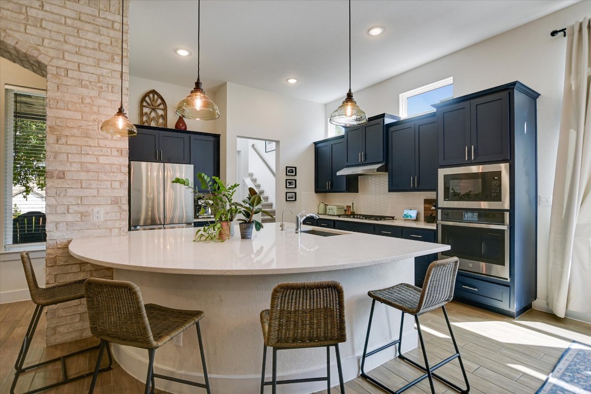 92 Rancho Trail Georgetown, TX 78628 - Photo 9 of 27 a kitchen with stainless steel appliances a dining table chairs refrigerator and microwave