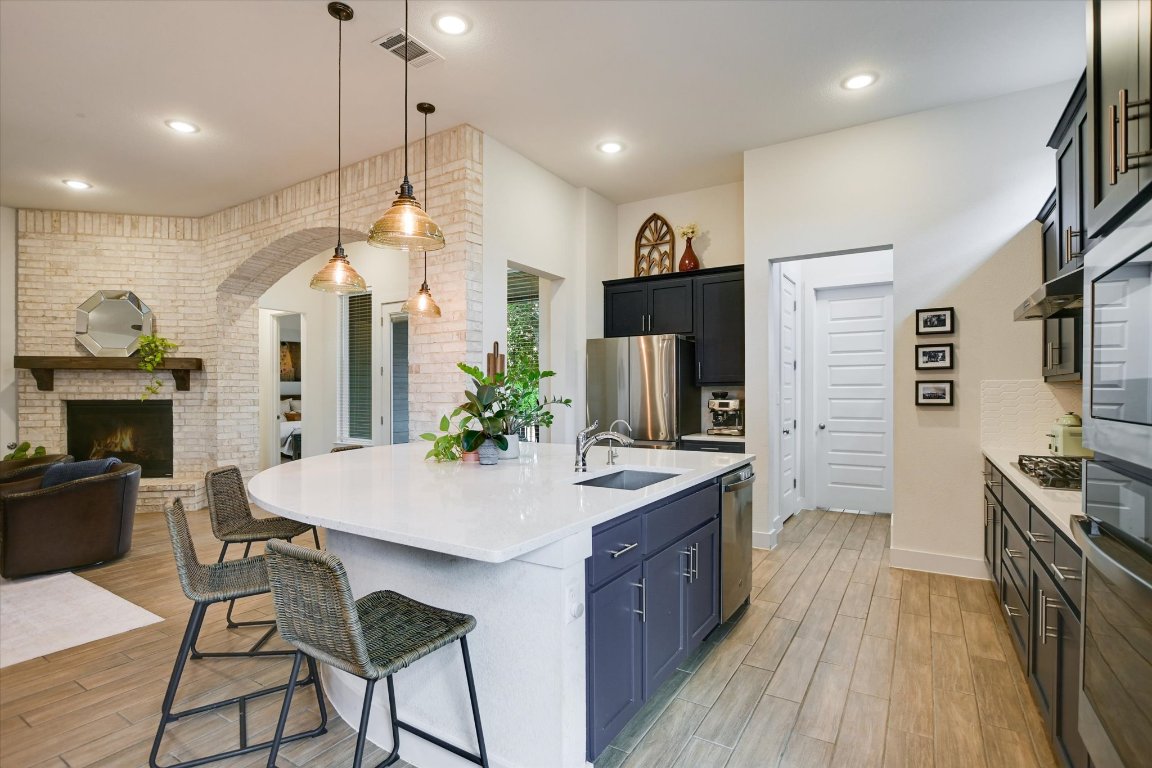 92 Rancho Trail Georgetown, TX 78628 - Photo 27 of 27 a kitchen with granite countertop a stove a sink a refrigerator and a wooden floor