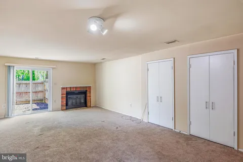 an empty room with windows and fireplace