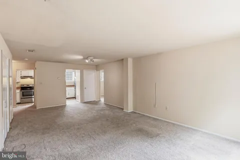 a view of an empty room with a kitchen