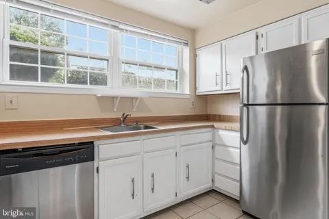 a kitchen with appliances a sink and cabinets