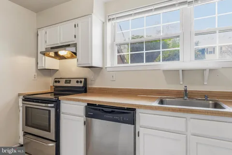 a kitchen with a sink stove and cabinets
