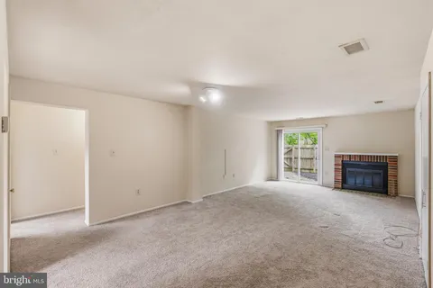 an empty room with windows and fireplace