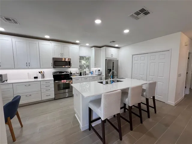 a kitchen with white cabinets and stainless steel appliances
