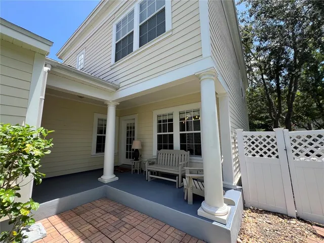 a view of a porch with chairs and potted plants