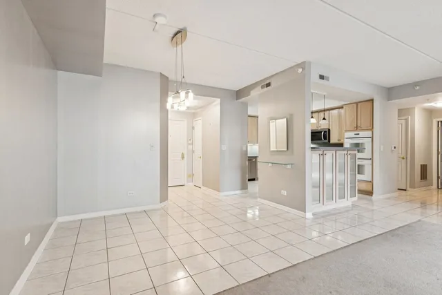 a view of a hallway with wooden cabinet and a refrigerator
