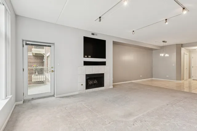 en empty room with windows and fireplace