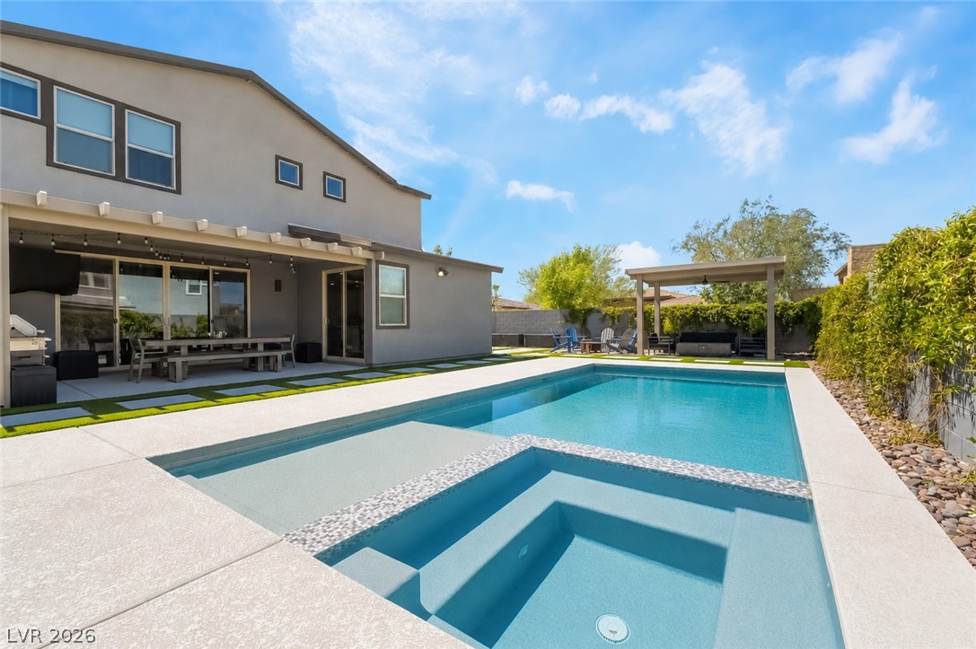 2166 Trivero Street Henderson, NV 89044 - Photo 42 of 61 An inviting backyard oasis offers a sparkling pool and spa, perfect for relaxation and outdoor entertaining.