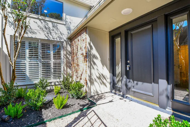 a view of house with backyard and glass windows