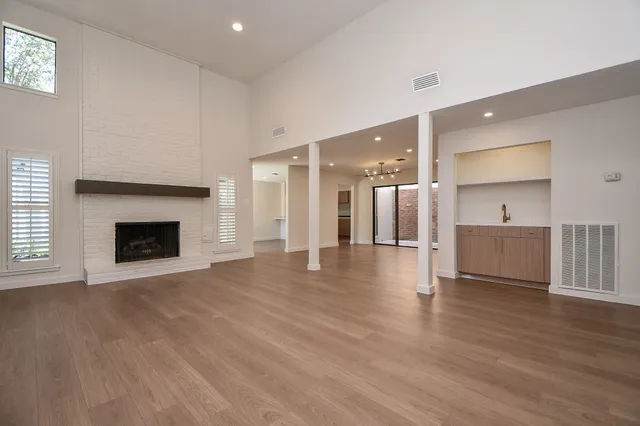 a view of a kitchen with a sink a fireplace and a window