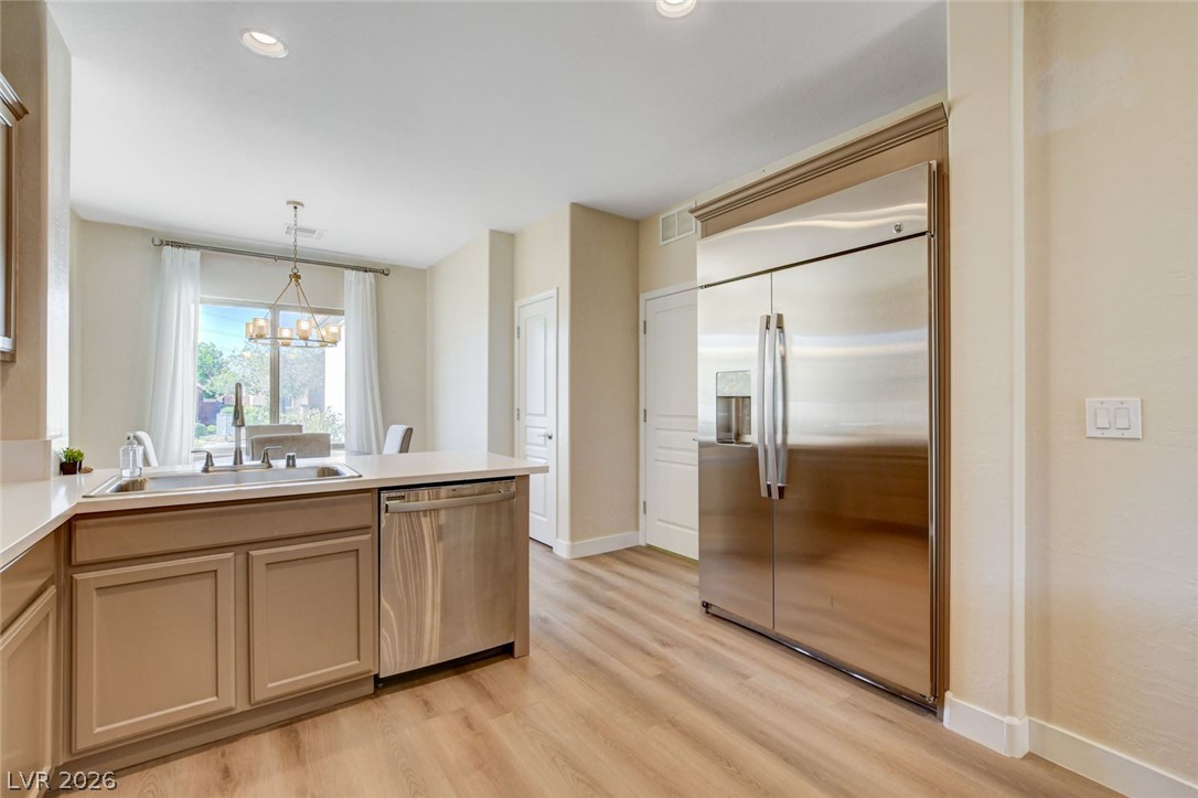 2649 Rue Marquette Avenue Henderson, NV 89044 - Photo 24 of 55 A well-lit kitchen featuring stainless steel appliances and durable wood flooring.