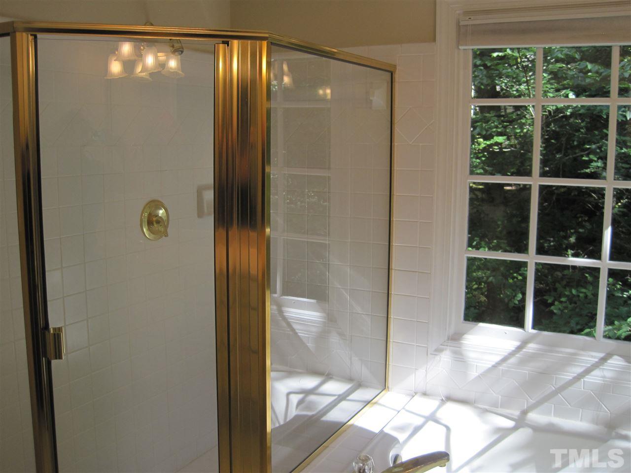 9904 Bright Hedge Court Raleigh, NC 27613 - Photo 14 of 20 a bathroom with a glass shower door