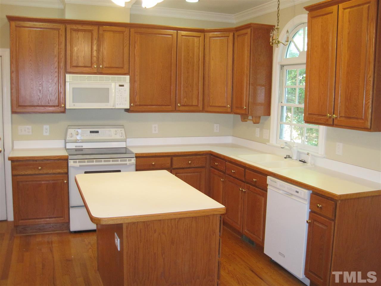 9904 Bright Hedge Court Raleigh, NC 27613 - Photo 7 of 20 a kitchen with a sink a stove cabinets and wooden floor