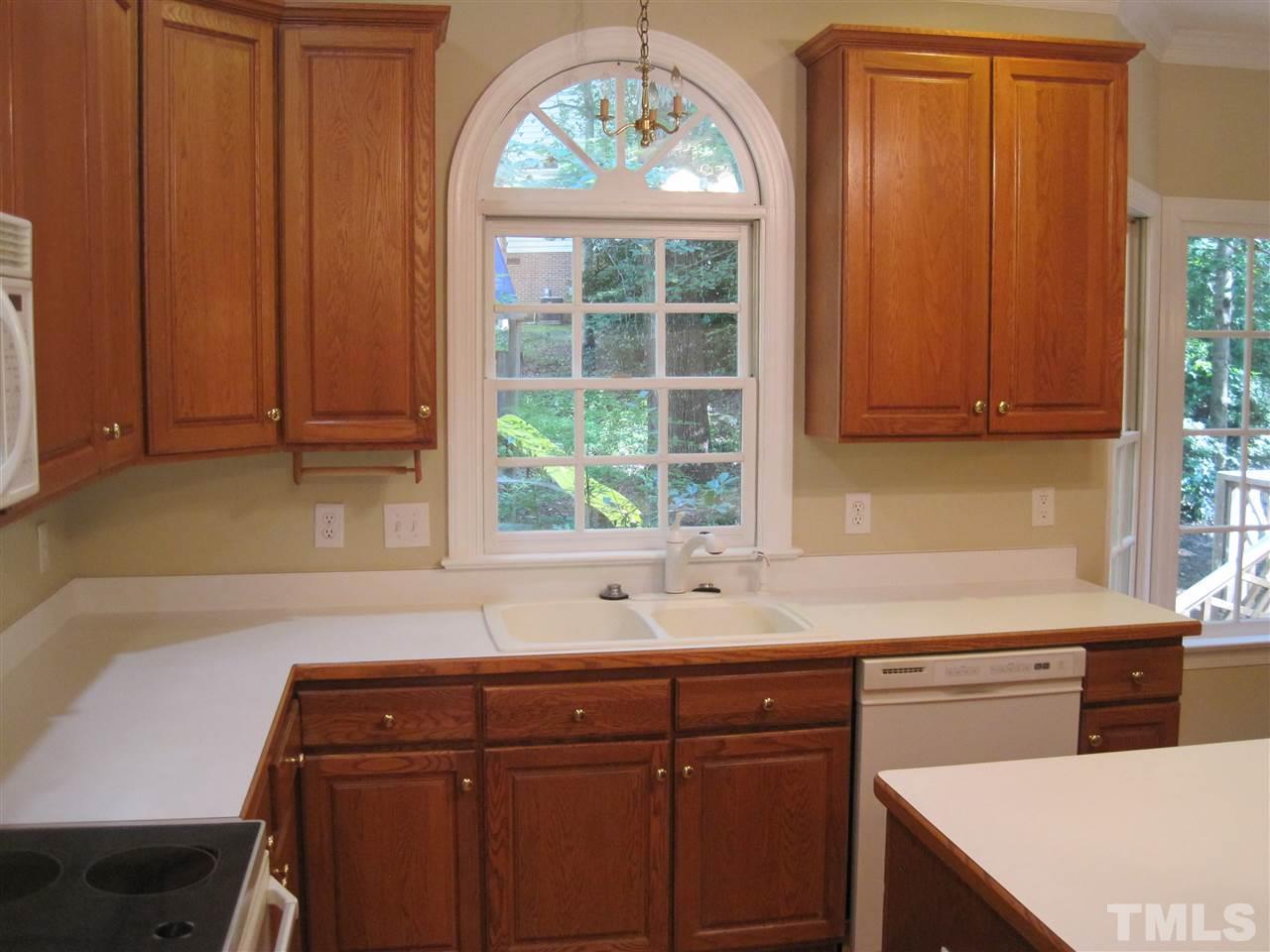 9904 Bright Hedge Court Raleigh, NC 27613 - Photo 8 of 20 a kitchen with stainless steel appliances granite countertop wooden cabinets a sink and a large window