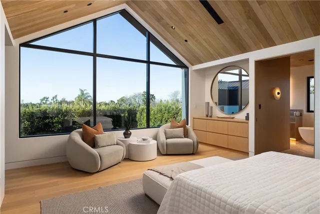 a bedroom with furniture and a large window