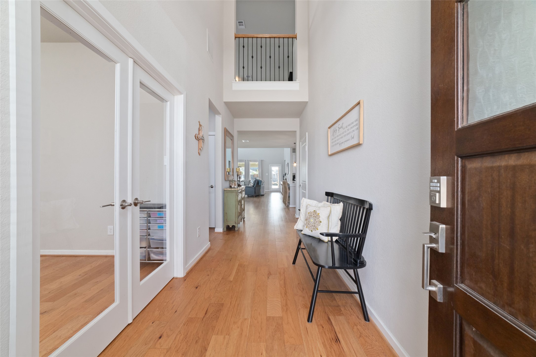 22122 Sam Raburn Drive Tomball, TX 77375 - Photo 5 of 47 Step inside to a light-filled entry with warm wood flooring, soaring ceilings, a welcoming hallway that opens seamlessly to the main living areas.