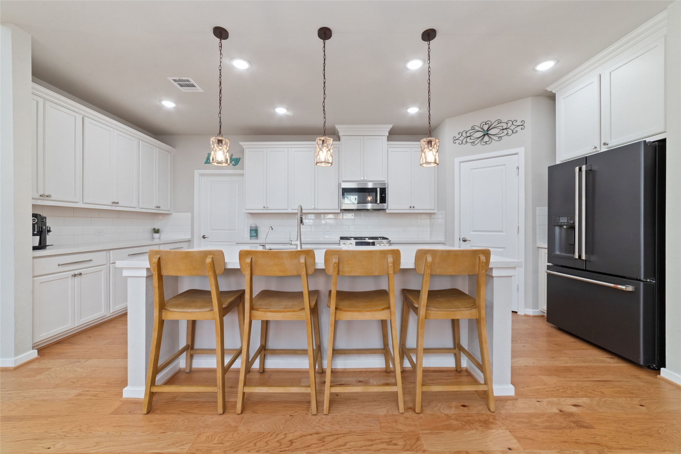 22122 Sam Raburn Drive Tomball, TX 77375 - Photo 9 of 47 The light and bright kitchen features a large quartz island, white cabinets, a large stainless steel sink, Bosch appliances, overlooking the dining and family room.