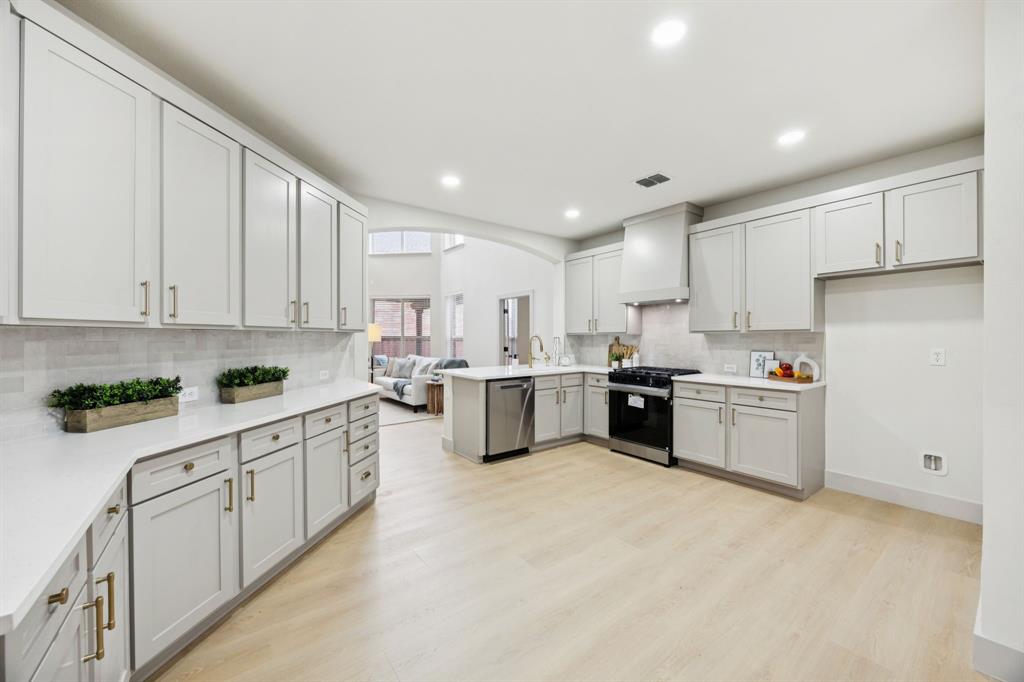 2437 Clear Field Drive Plano, TX 75025 - Photo 13 of 38 a kitchen with white cabinets stainless steel appliances and sink