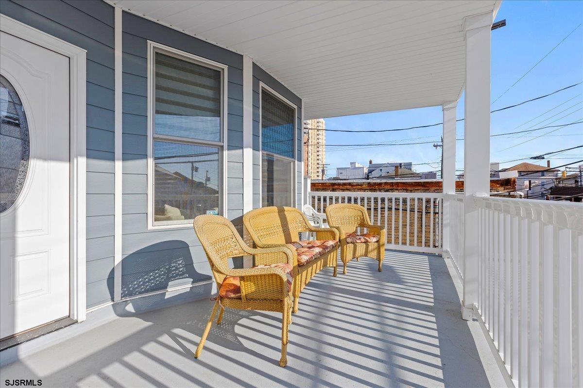 27 South Little Rock Avenue, Unit MAY 2026 Ventnor City, NJ 08406 - Photo 14 of 91 a view of a deck with table and chairs with wooden floor and fence