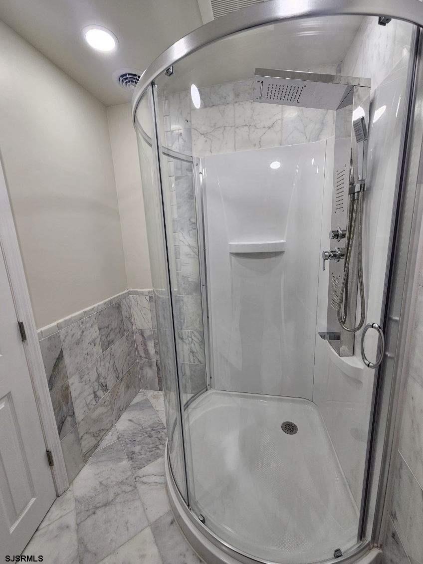 27 South Little Rock Avenue, Unit MAY 2026 Ventnor City, NJ 08406 - Photo 39 of 91 a bathroom with a shower and a mirror