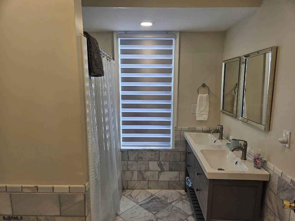 27 South Little Rock Avenue, Unit MAY 2026 Ventnor City, NJ 08406 - Photo 40 of 91 a bathroom with a sink and a mirror