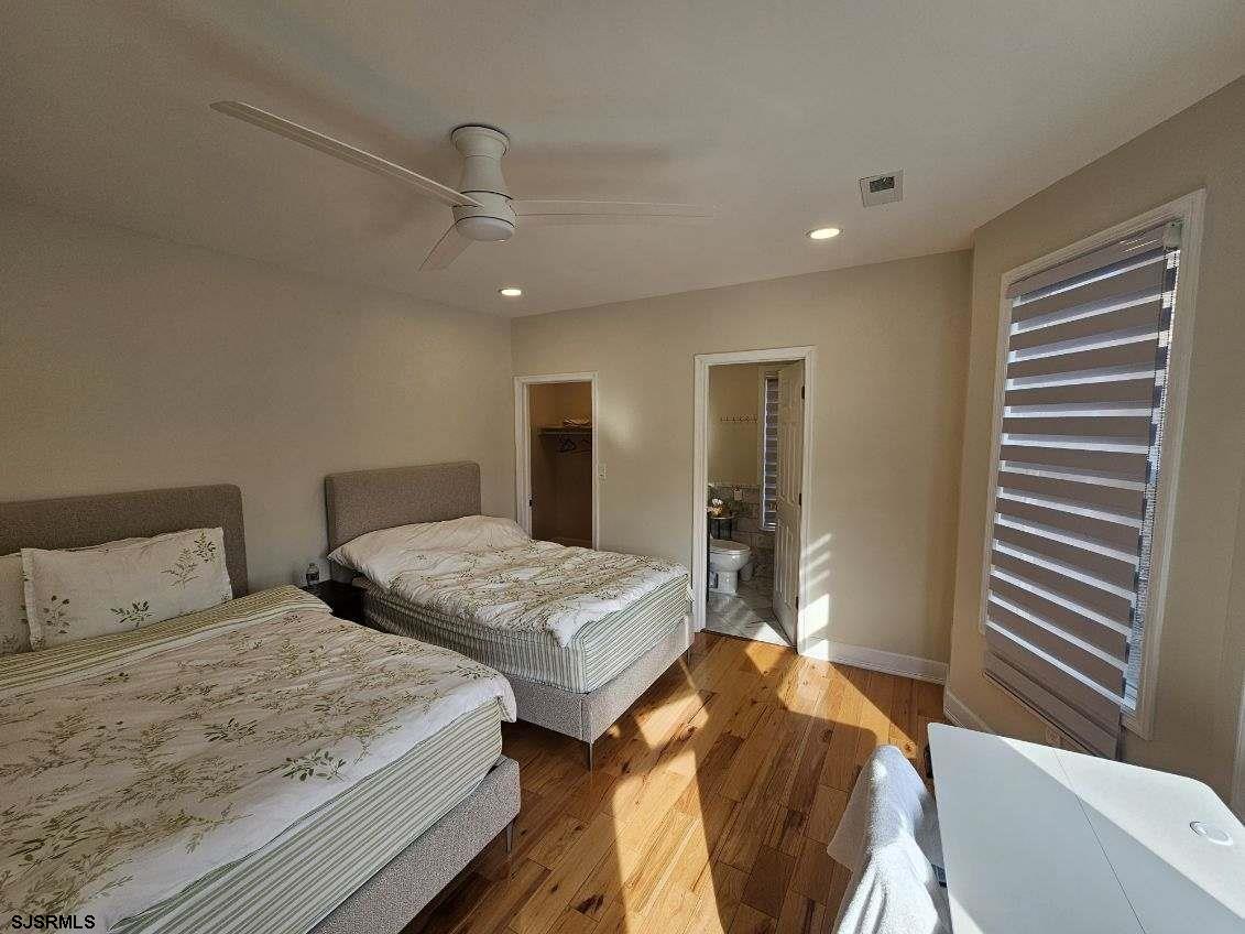 27 South Little Rock Avenue, Unit MAY 2026 Ventnor City, NJ 08406 - Photo 54 of 91 a bedroom with two beds and a chandelier