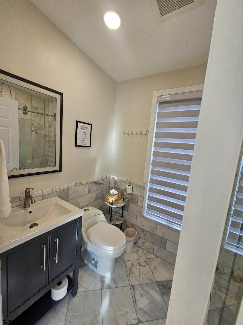 27 South Little Rock Avenue, Unit MAY 2026 Ventnor City, NJ 08406 - Photo 82 of 91 a bathroom with a sink a toilet and mirror