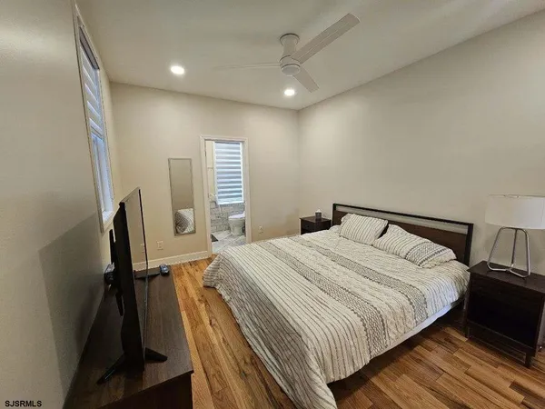 a bedroom with a bed and wooden floor