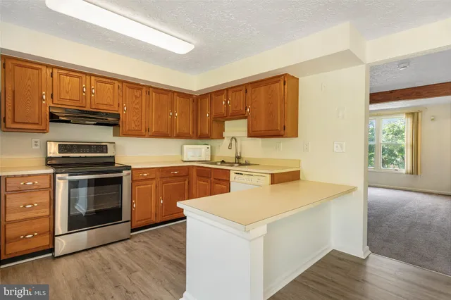 a kitchen with stainless steel appliances granite countertop a stove a sink and a microwave