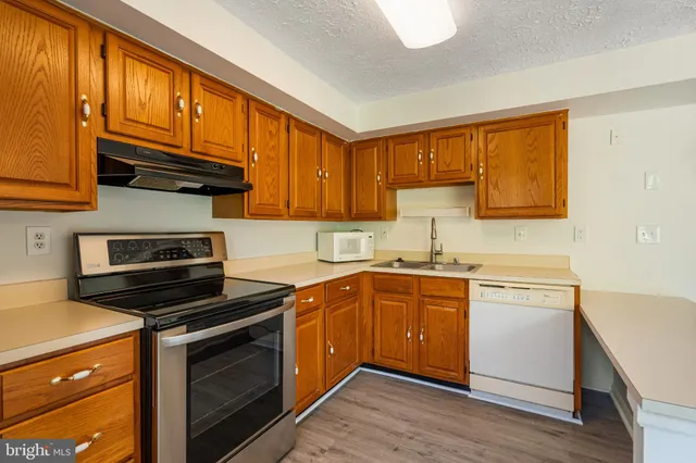 a kitchen with a sink cabinets and wooden floor