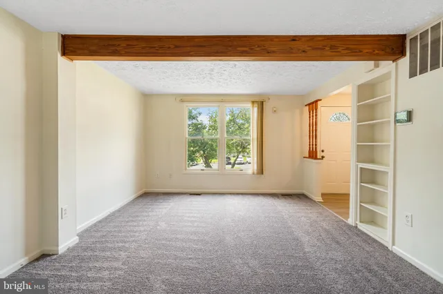 an empty room with a ceiling fan and window