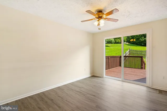 a kitchen with stainless steel appliances a stove a refrigerator a sink and a view of dining hall with wooden floor