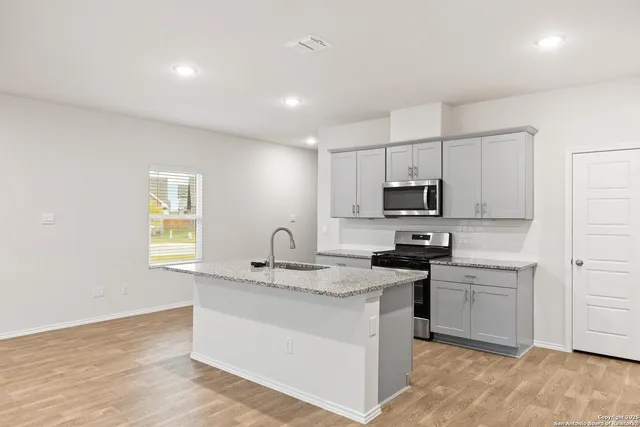 a kitchen with a sink stove and cabinets