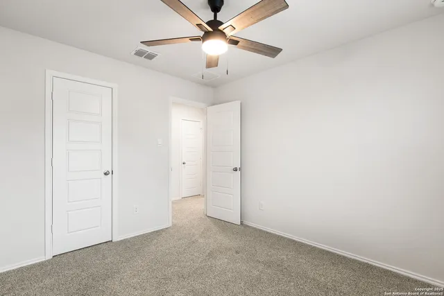 an empty room with a window and a ceiling fan