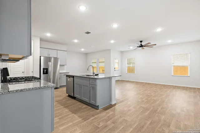 a kitchen with white cabinets and stainless steel appliances
