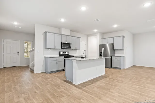 a kitchen with stainless steel appliances granite countertop a sink stove and refrigerator
