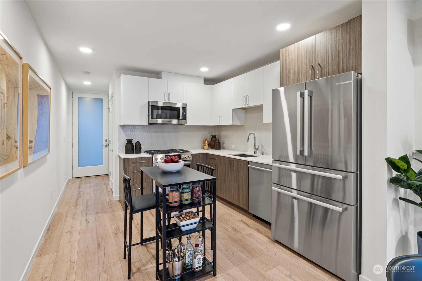 1425 East Howell Street Seattle, WA 98122 - Photo 5 of 20 a kitchen with stainless steel appliances granite countertop a refrigerator a stove a sink a microwave and a dining table with wooden floor